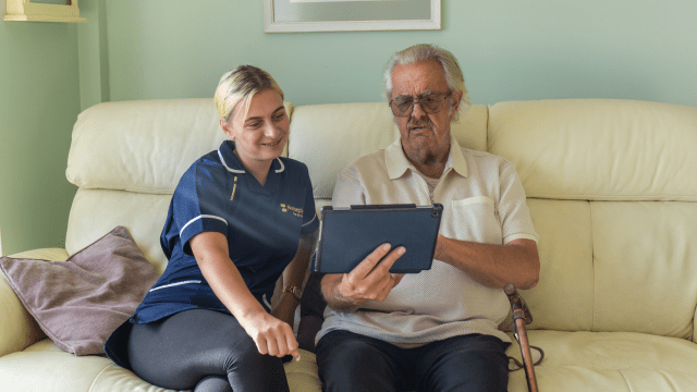 Nurseplus carer helping elderly man with a tablet