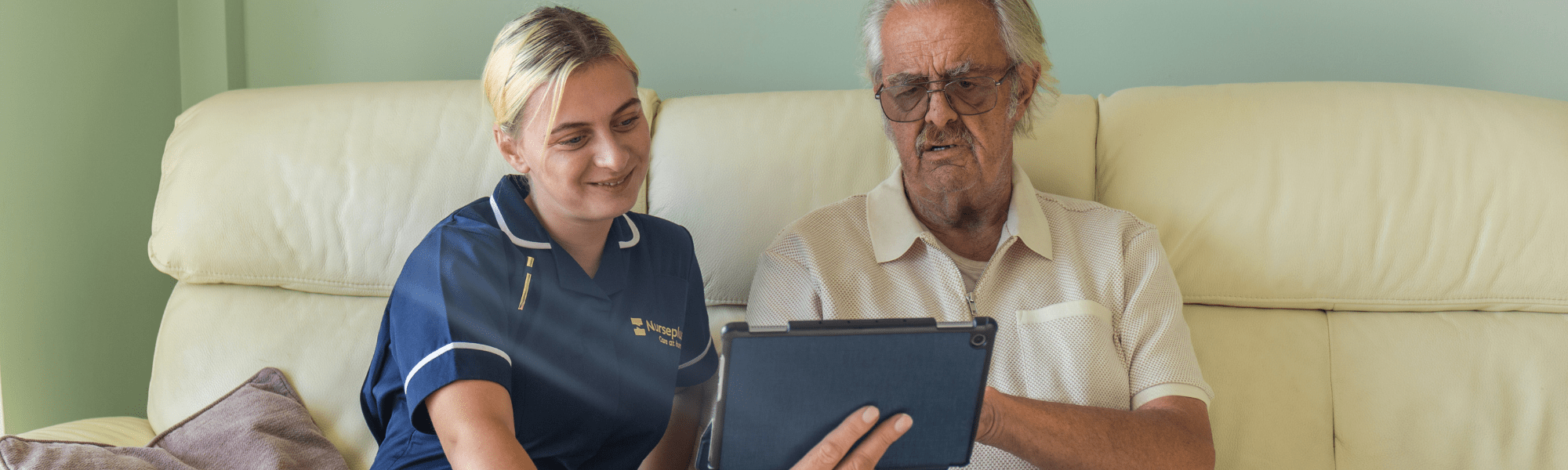 Nurseplus carer helping elderly man with a tablet